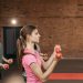 Group of adults exercising indoors with dumbbells, focused on fitness and health.