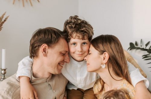 A joyful family moment with parents and their son embracing indoors.