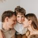 A joyful family moment with parents and their son embracing indoors.